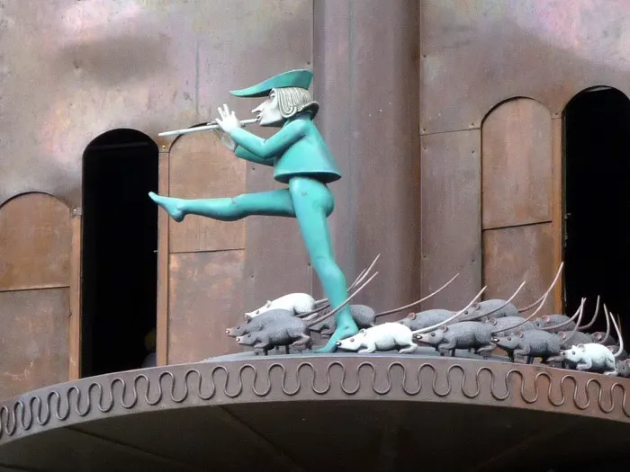Rattenfänger-Figur mit Flöte, gefolgt von Ratten, am Glockenspiel in Hameln